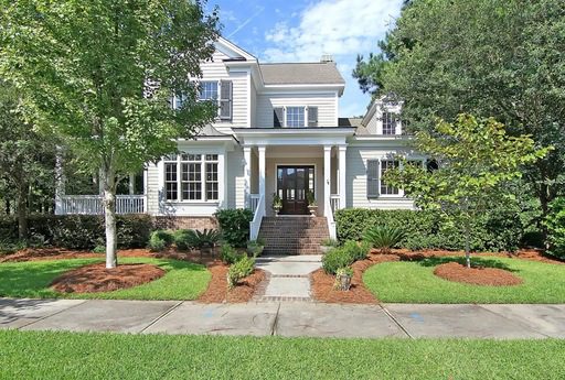 A two story white coloured house with lawn in front of it and trees at 309 Gunboat Lane Daniel Island, SC 29492