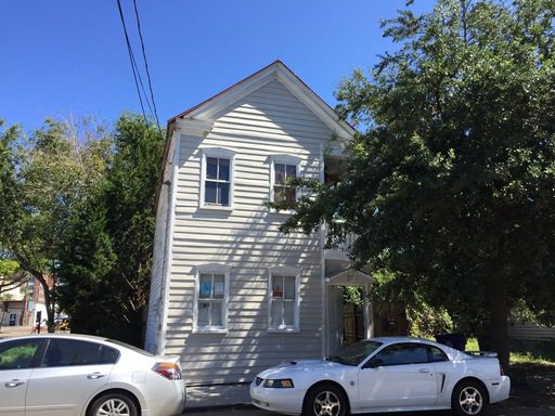 A two story house yellow coloured house with cars park outside at 208 St. Philip Street Charleston, SC 29403