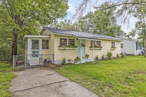 A single story house with lots of greenery outside