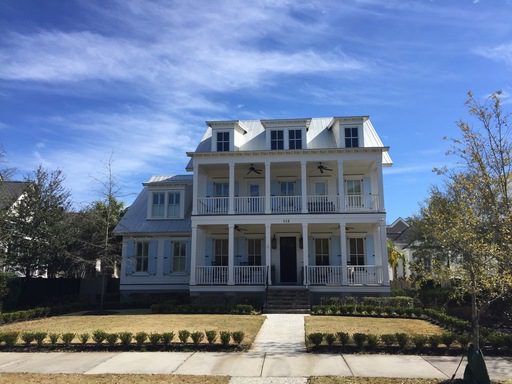 A two story white large house with huge frontyard at Island Park Drive Daniel Island, SC 29492