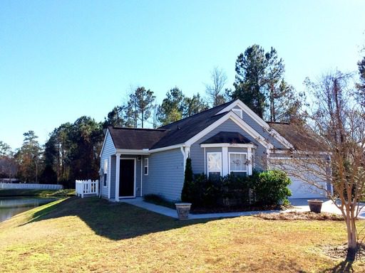 A single story black coloured house and lawn in front of it at Palm Cove Drive Charleston, SC 29464