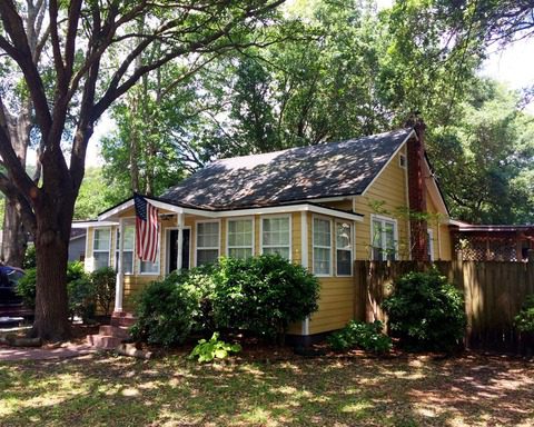 A single story house with american flag hanging and bushes surrounding the house at Jessamine Road Charleston, SC 29407