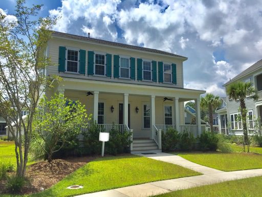 An image of a beautiful yellow coloured house with lawn upfront