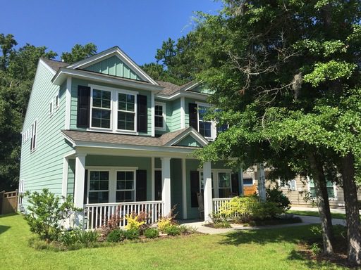 A two story green colour house with lawn and large tree in front of it at 1625 Sparkleberry Lane Johns Island, SC 29455