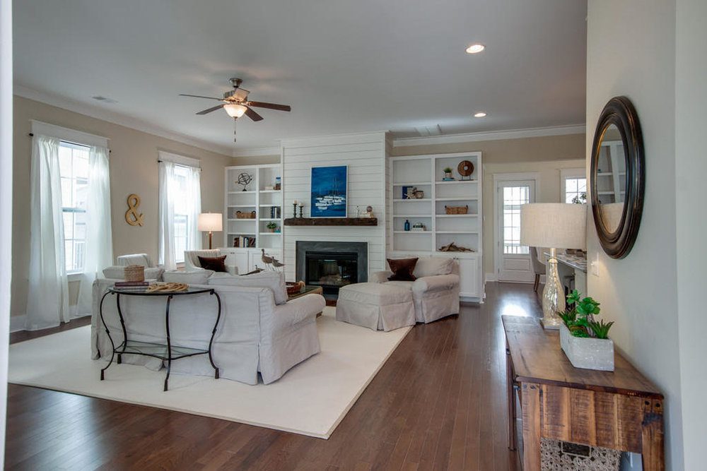 An inside image of white coloured living room with sofas and fireplace at Carolina Park in Mount Pleasant.