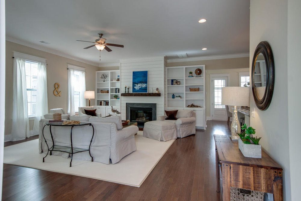 An inside image of white coloured living room with sofas and fireplace at Carolina Park in Mount Pleasant.