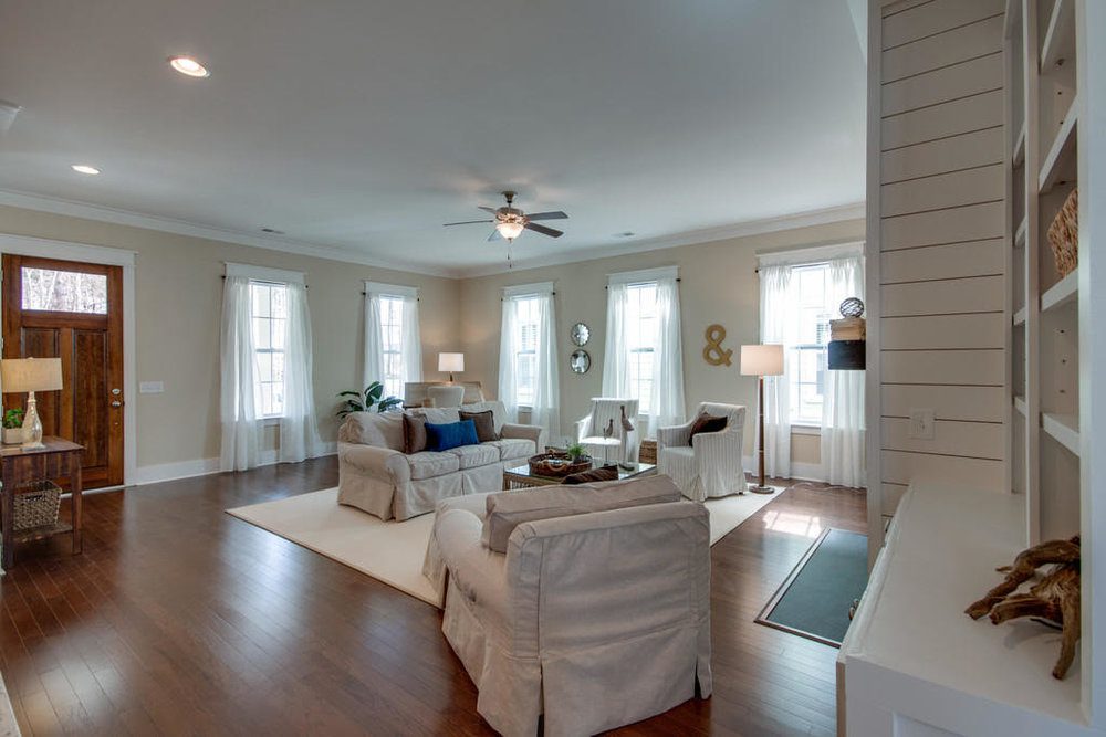 An inside image of white coloured living room with sofas at Carolina Park in Mount Pleasant.