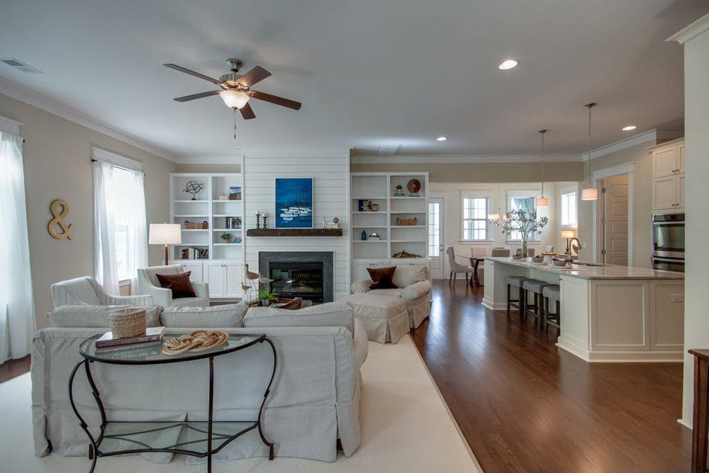 An inside image of white coloured living room with sofas and fireplace at Carolina Park in Mount Pleasant.