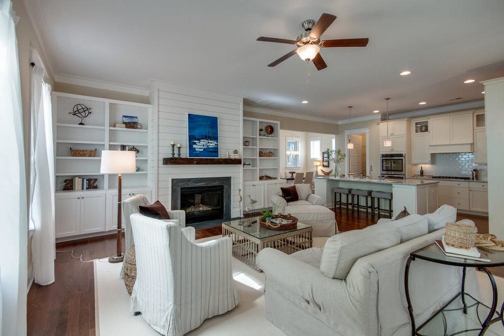 An inside image of white coloured living room with sofas and fireplace at Carolina Park in Mount Pleasant.