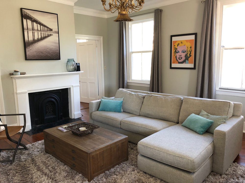 An inside image of the well furnished living room with fireplace next to sofa in the apartment