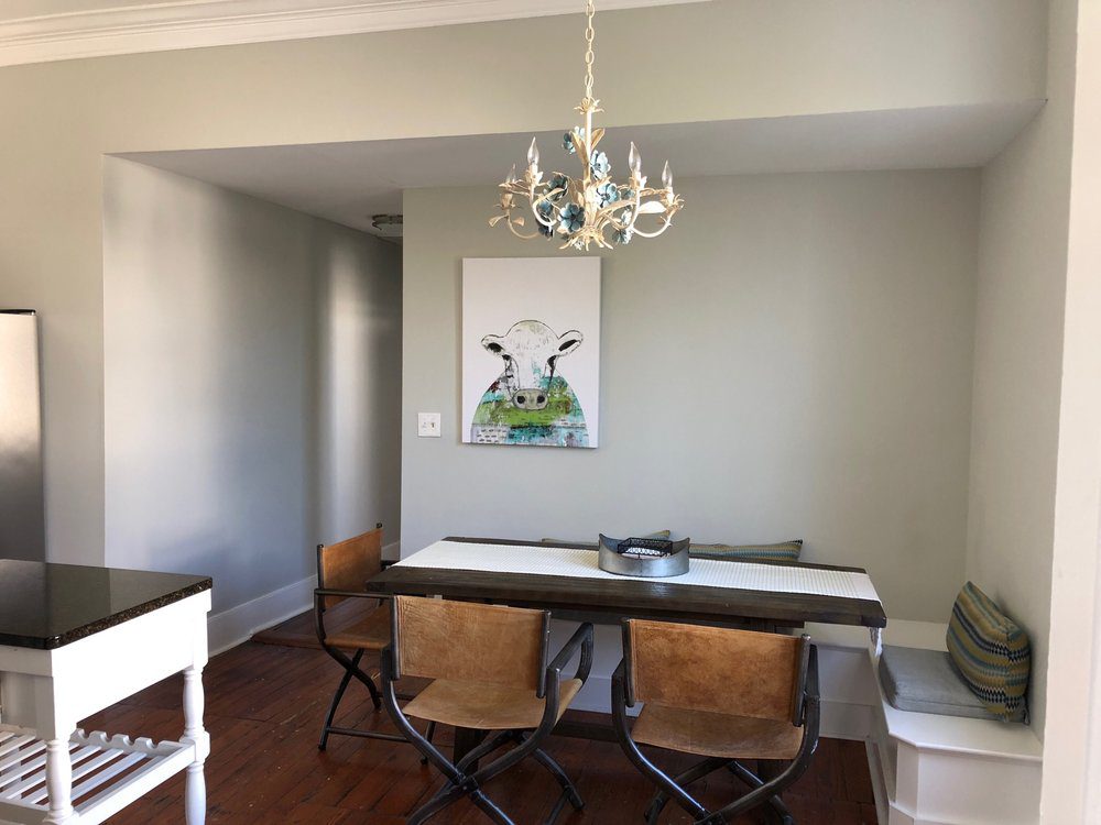 An inside image of the dining table with a cow painting above it in the apartment