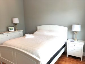 An image of the bedroom with white bed