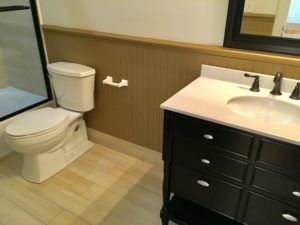 An inside image of restroom with white top basin and white toilet seat