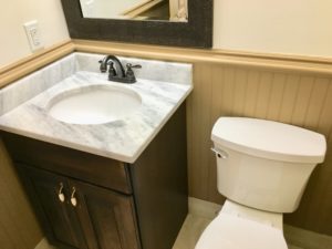 An inside image of restroom with white top basin and white toilet seat