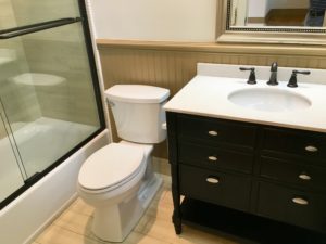 An inside image of restroom with white top basin and white toilet seat