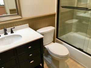 An inside image of restroom with white top basin and white toilet seat
