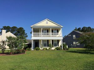 A two story yellow coloured house with large lawn in front of it at West Red Maple Circle Summerville, SC 29485