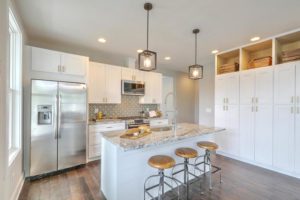 An inside image of the kitchen with counter and three round chairs