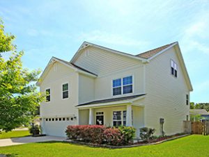 A yellow coloured two story house with huge green lawn upfront at Wapiti Way Hollywood, SC 29449