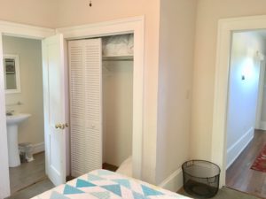 An image of a bedroom with bed and toilet in front of it