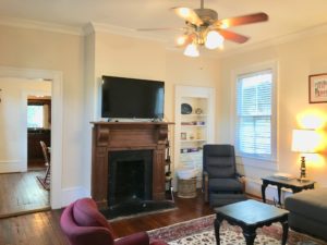 An image of living room with tv at A two story white coloured house at Elliotborough on the Charleston Peninsula