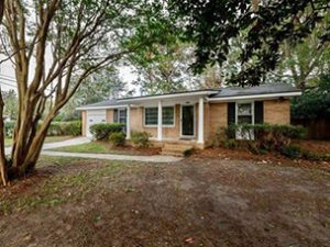 A single story orange house and large frontyard at Quail Drive Charleston, SC 29412