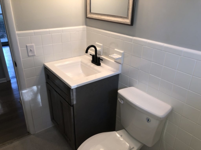 An inside image of the restroom with white sink top and toilet seat