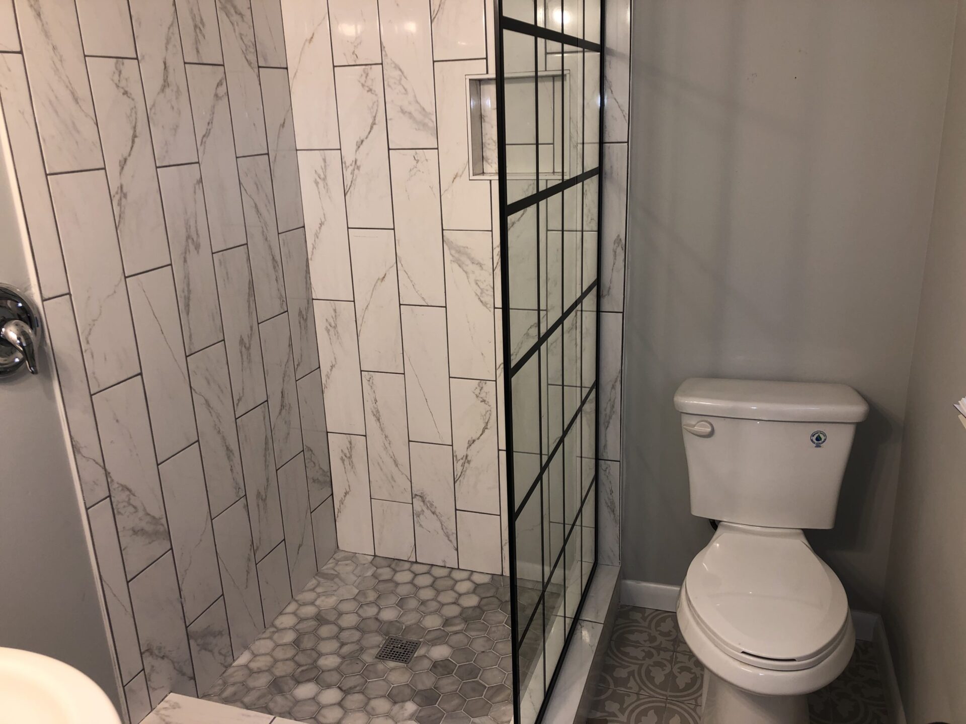 A shower booth and a toilet seat next to it