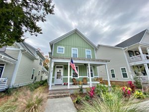 A two story green coloured house with lot of bushes upfront at Celtic Drive North Charleston, SC 29405