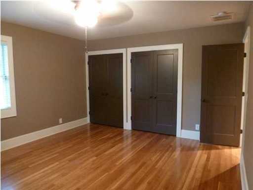 An empty room with wooden floor and two doors visible