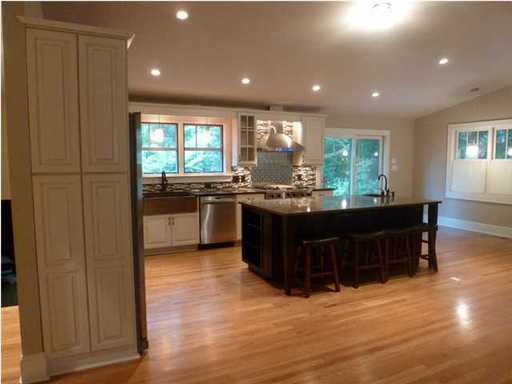An image of well lightened kitchen with brown square dining table