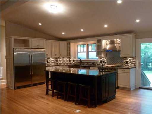An image of well lightened kitchen with brown square dining table